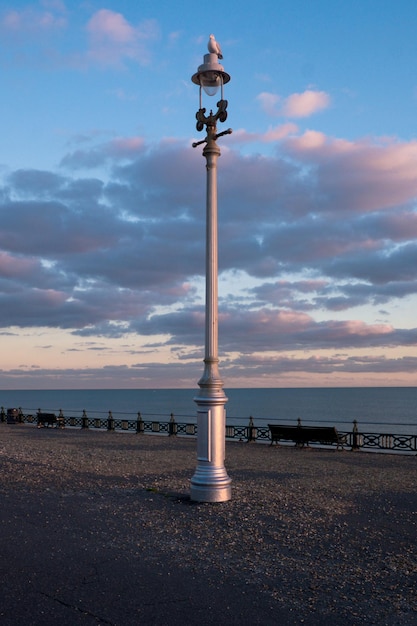 Foto statua sulla spiaggia al tramonto