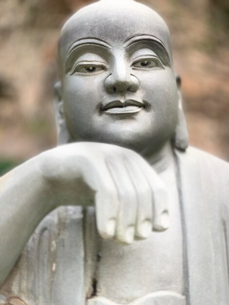 A statue of a buddha with the hand pointing to the left.