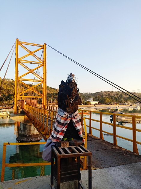 Photo statue by bridge over river against sky