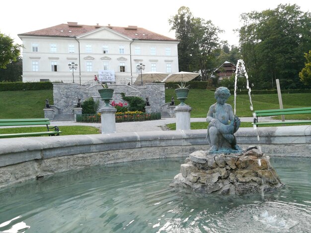 Statue by fountain against sky