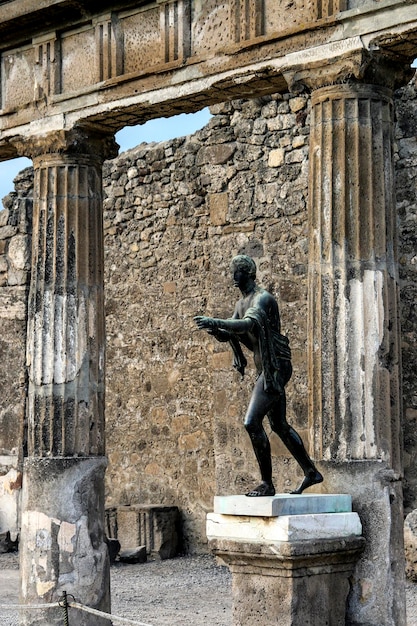 Foto statua vicino a una vecchia struttura in rovina