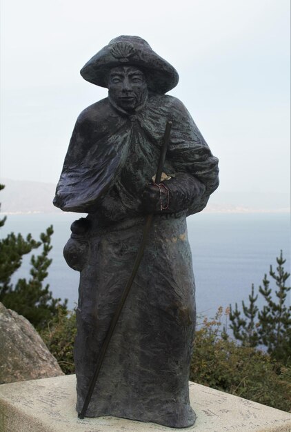 Foto statua dal mare contro il cielo