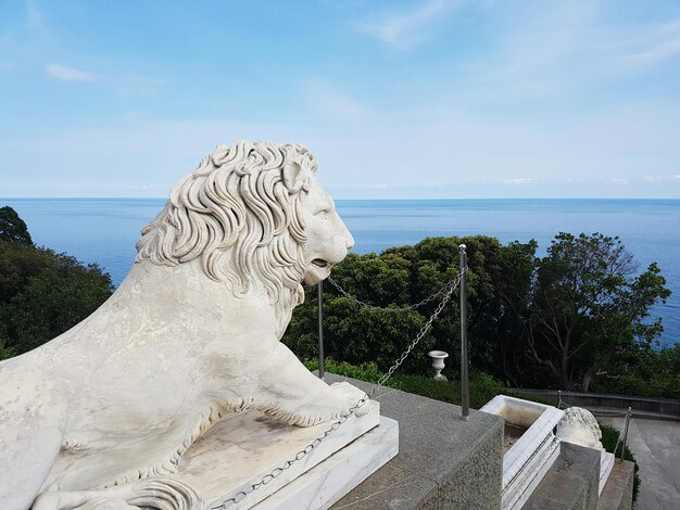 Statue by sea against sky