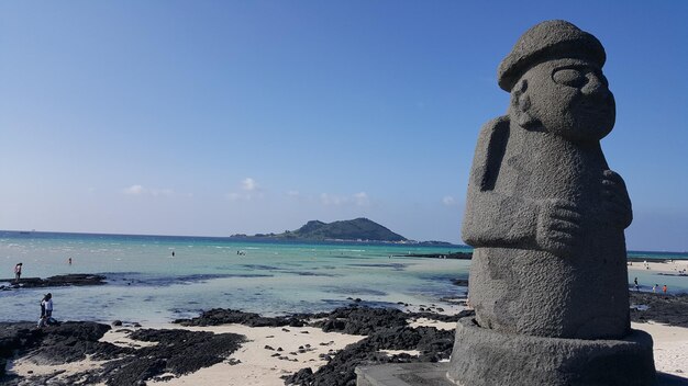 Foto statua dal mare contro il cielo