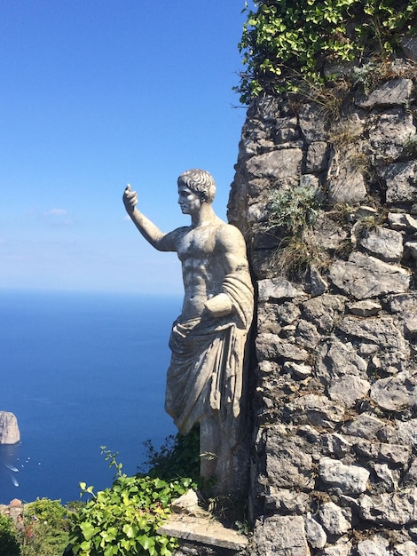 Photo statue by tree against sky