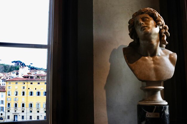 Foto statua vicino alla finestra di casa