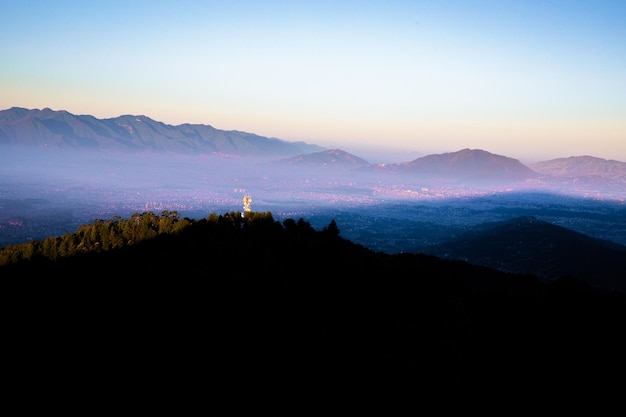 A statue of the cross on a hill in the distance.