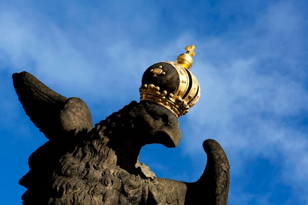 A statue of a eagle with a gold crown on its head