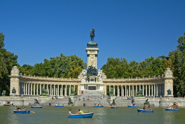 Foto statua di fronte al fiume contro un cielo blu limpido