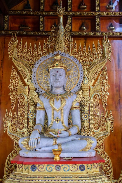 Photo a statue of a god sits on a wall with gold trim.