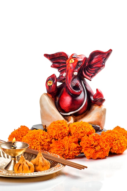 Statue of Hindu God Ganesha with Worship arrangement on white surface