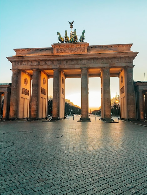 Photo statue of historical building - brandenburgergate during sunrise  empty during covid-19 lockdown