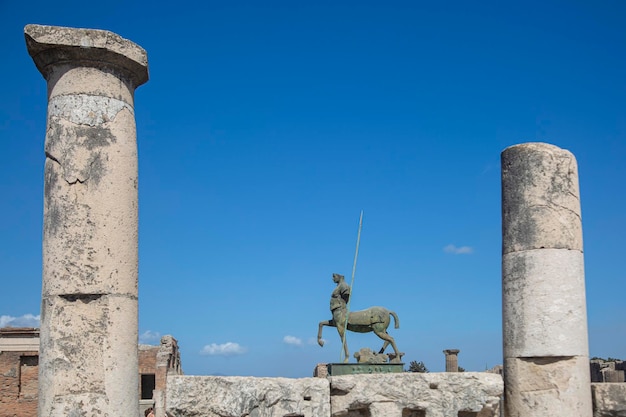 A statue of a horse and rider stands in front of a column.