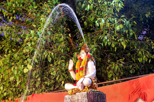 Statua del signore indiano shankar che esce dal gange dai capelli