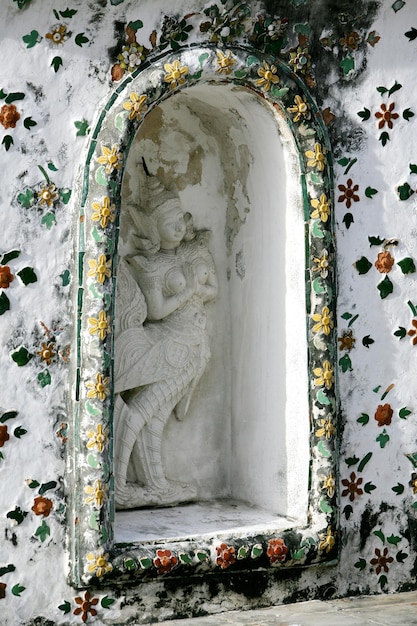 The statue is in the temple wall.