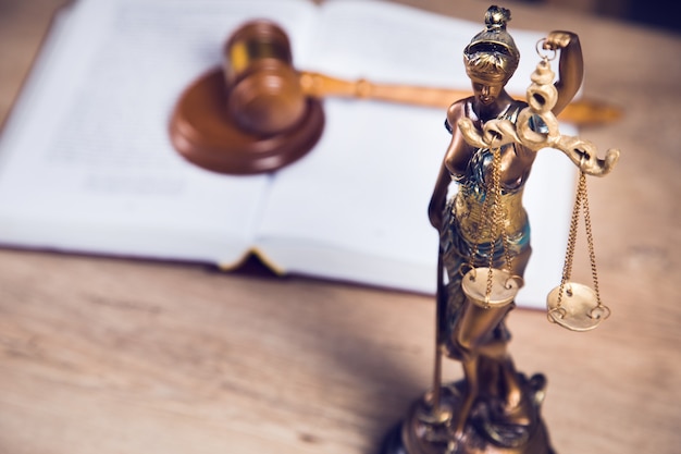 Statue of justice, book and gavel on wooden table