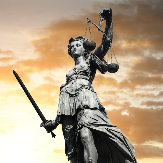 The Statue of Justice - lady justice or Iustitia / Justitia the Roman goddess of Justice against cloudy sunset sky. ideal for websites and magazines layouts