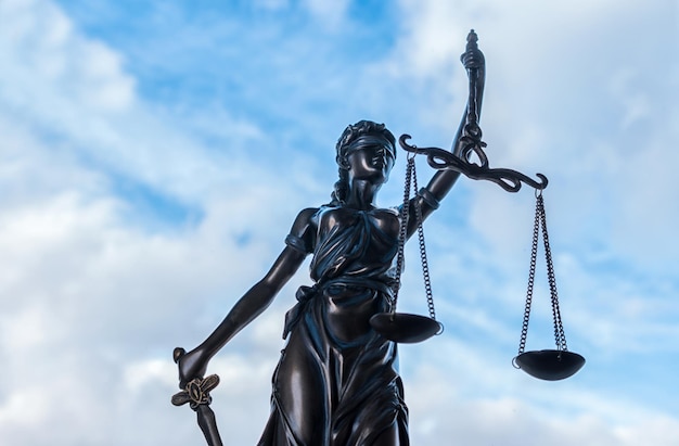 Statue of Justice symbol with cloudy sky background