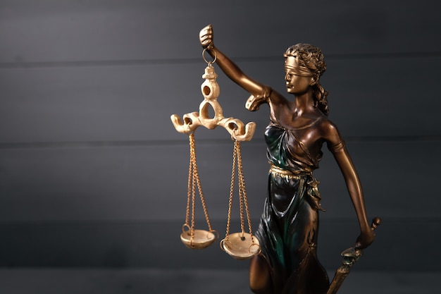 Statue of justice on wooden background