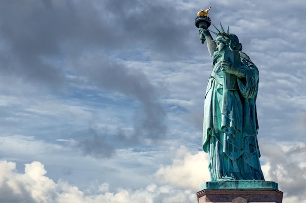 Statue of liberty in New York on blue cloudy sky