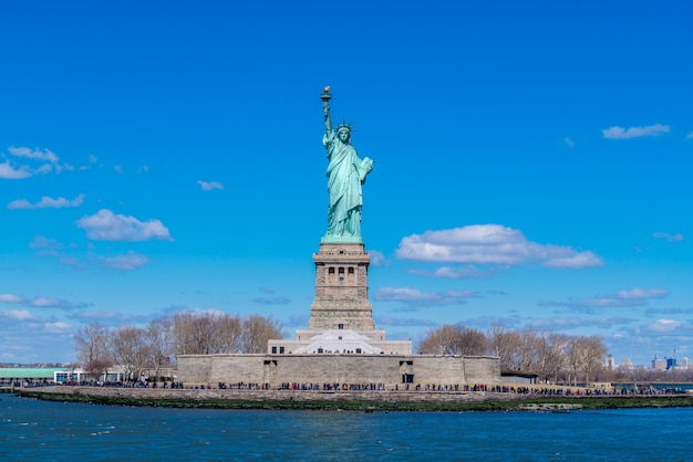 Foto la statua della libertà a new york city. statua della libertà con cielo blu sopra il fiume hudson sull'isola. punti di riferimento di manhattan più basso new york city.