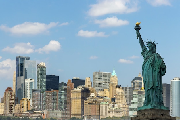 La statua della libertà con il fiume hudson e i punti di riferimento del paesaggio urbano di new york nella parte inferiore di manhattan new york city.