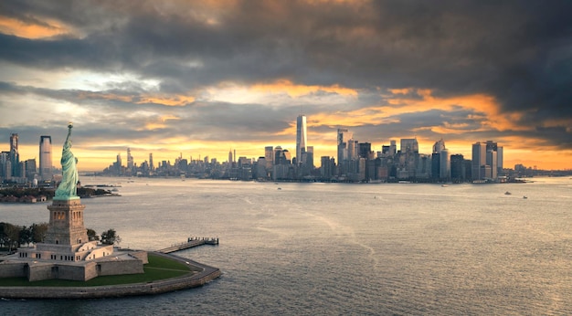 The Statue of Liberty with Lower Manhattan background in the evening at sunset Landmarks