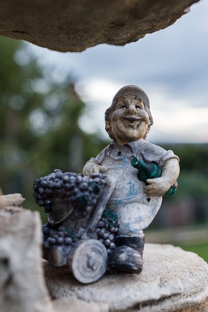 Photo a statue of a man holding a bunch of grapes