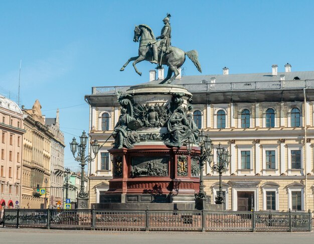 A statue of a man on a horse is in front of a building.