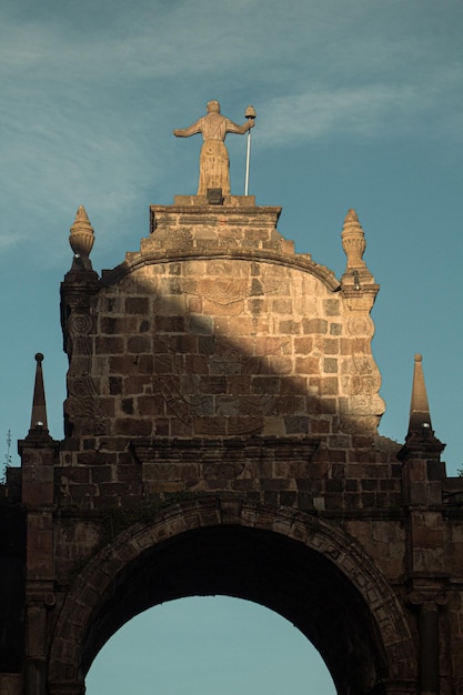 Photo a statue of a man on a stone bridge with a statue on top of it