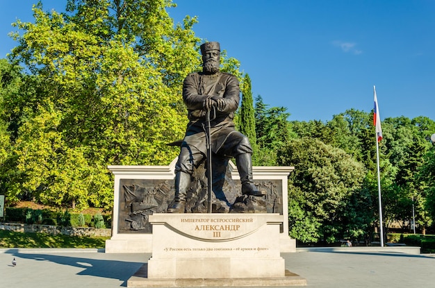 Photo a statue of a man in a suit sits in a park.