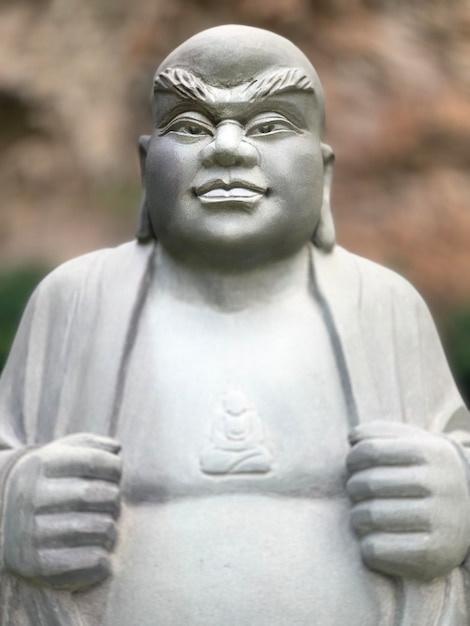A statue of a man with a sign that says " buddha " on it.