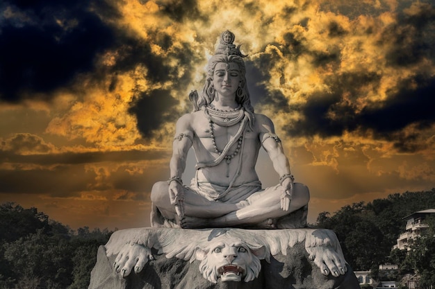 Photo statue of meditating hindu god shiva on the ganges river at rishikesh village in india