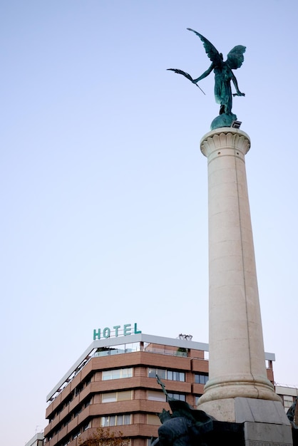 사진 백그라운드에서 jaen시의 plaza de las batallas에 위치한 천사의 동상은 호텔의 컷입니다.