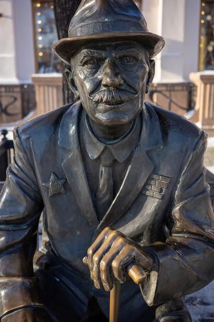 Фото Статуя ветерана великой отечественной войны, сидящего на скамейке