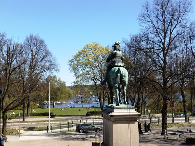 Statue in park against clear blue sky