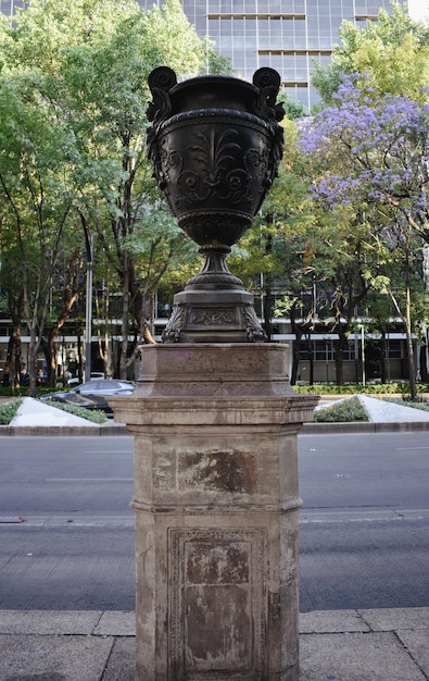 Photo a statue on a pedestal in a park with trees in the background