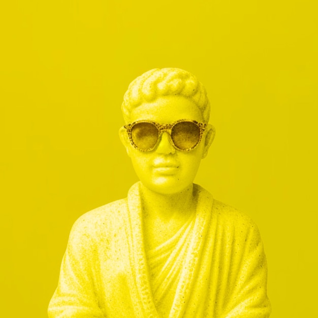 Статуя человека в солнечных очках на желтом фоне