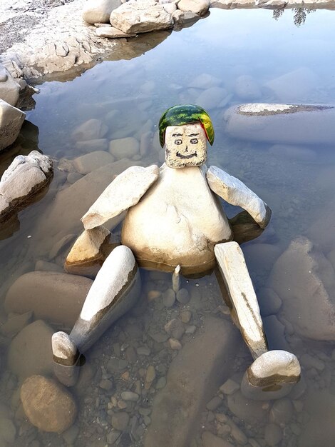 Foto statua su una roccia vicino al lago