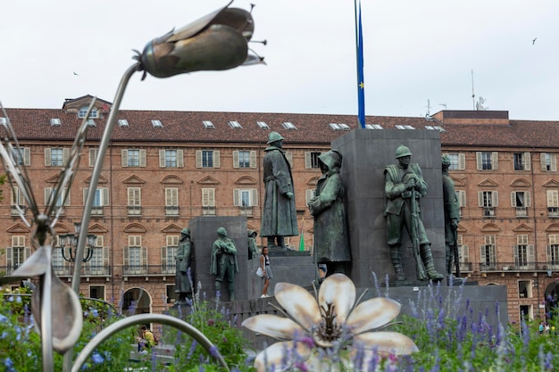 A statue of a soldier stands in front of a building with a flag on it.