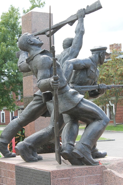 A statue of a soldier with a spear and a hat on it