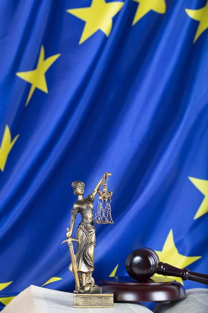 Статуя Фемиды на флаге Европейского Союза. Молоток судьи на заднем плане