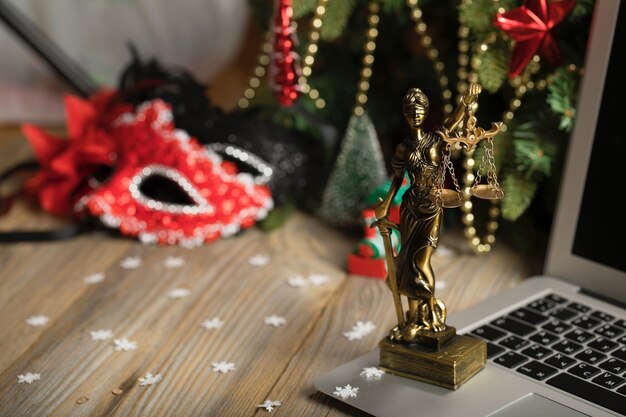 Statue of Themis placed on a laptop New Years Day background