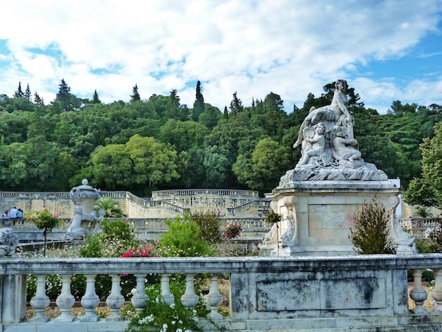 statue of trees and plants against cloudy sky
