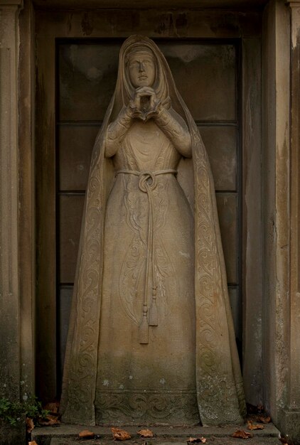 Una statua di una donna che tiene una tazza tra le mani.