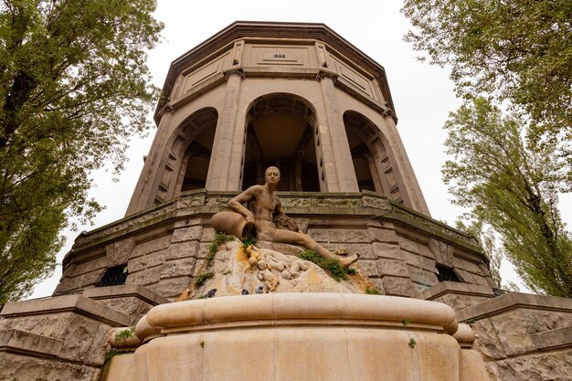 Photo a statue of a woman in a park with a building in the background.