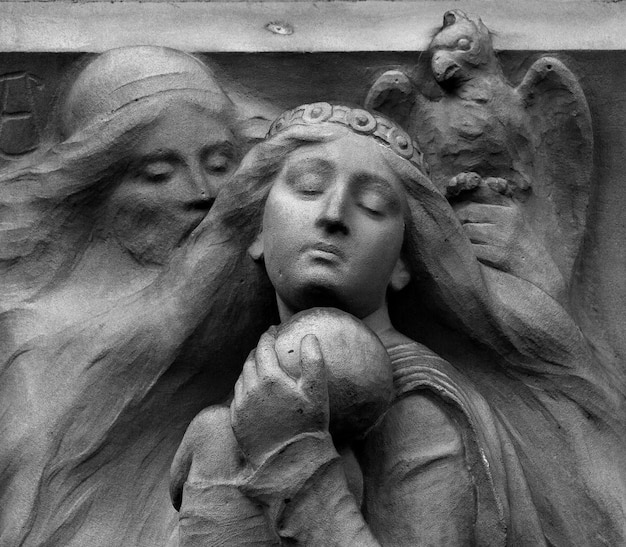 공을 머리에 이고 있는 여성의 동상이 새에 둘러싸여 있습니다.