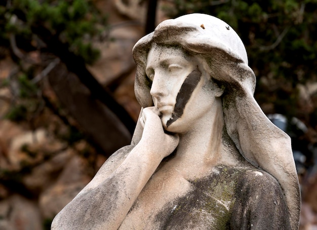 A statue of a woman with a black and white paint on her face