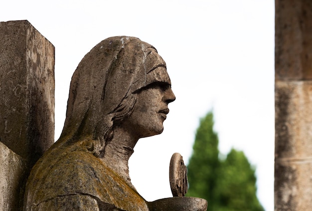 A statue of a woman with a cross on her head