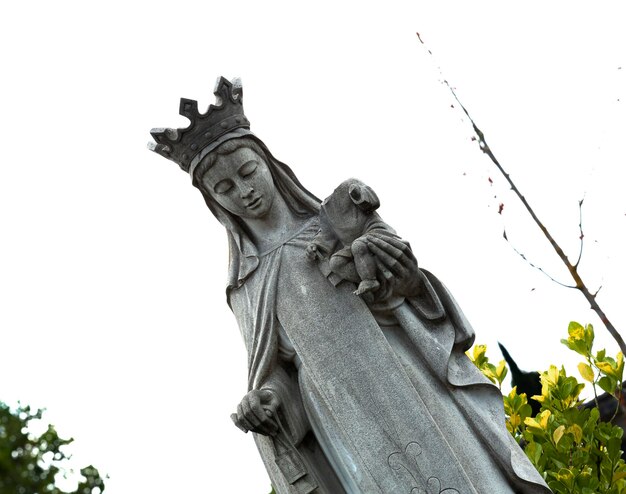 Photo a statue of a woman with a crown on her head is holding a bird.
